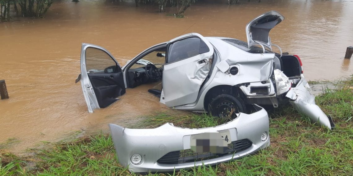 Carro sai da pista e cai em córrego alagado na BR-459