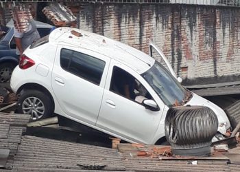 Carro cai em cima de telhado em Poços