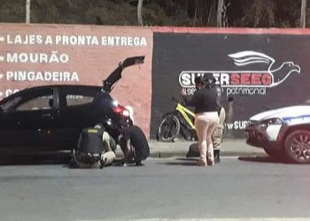 Policial ajuda mulher trocando pneu furado de veículo em Poços de Caldas