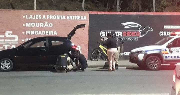 Policial ajuda mulher trocando pneu furado de veículo em Poços de Caldas