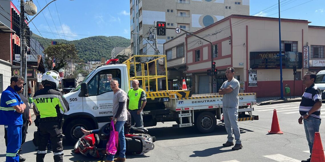 Mulher inabilitada para conduzir moto avança sinal e bate em caminhão do Demutran em Poços