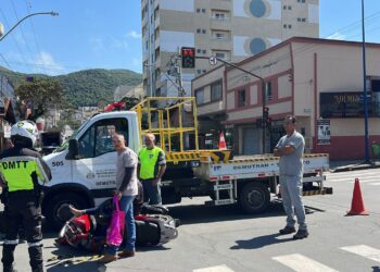 Mulher inabilitada para conduzir moto avança sinal e bate em caminhão do Demutran em Poços