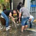 Lojistas desentopem bueiros durante alagamento em Poços de Caldas