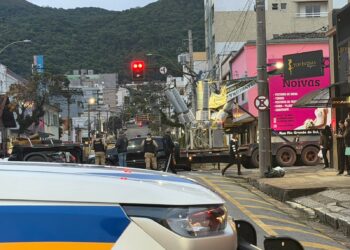Caminhão danifica poste de iluminação após enroscar em faixa em cruzamento
