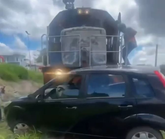 Carro fica destruído após ser atingido e arrastado por trem